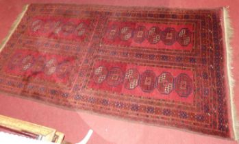 A Persian woollen red ground bokhara rug, 210 x 111cm