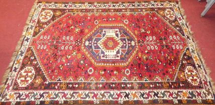 A Persian woollen red ground shiraz rug, 165 x 116cm