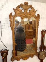 An early Georgian style carved pine floral decorated rectangular wall mirror, surmounted with