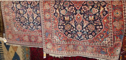 A pair of Persian red and blue ground Isfahan woollen rugs, each 160 x 106cm Overall in very good