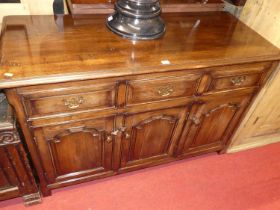 A contemporary joined oak dresser base, having three frieze drawers over conforming recessed