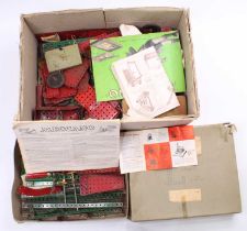 A box containing a collection of vintage Meccano including various flat plates, gear wheels, and