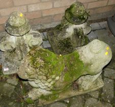 A pair of reconstituted stone garden gate post finials, together with a garden concrete recumbent
