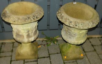 A pair of reconstituted stone pedestal urn garden planters, each dia 43cm
