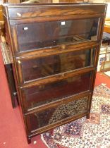 A 1930s oak four tier stacking book case, having typical hinged glazed doors, width 87cm