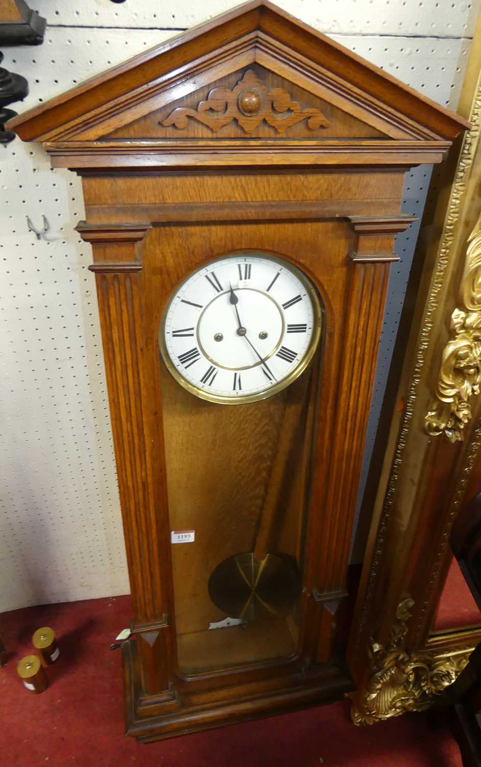 A late 19th century oak cased Vienna wall clock by Lenzkirk, having an unsigned white enamel Roman