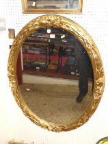 A contemporary floral gilt decorated oval wall mirror in the Regency taste, 95 x 72.5cm