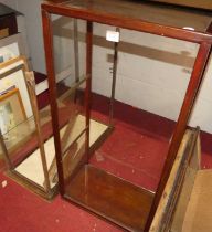 A retailer's stained beechwood and glazed counter-top cabinet, with two glass shelves, h.85cm;