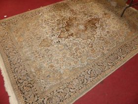 A Persian woollen pale ground Tabriz rug, the central floral decorated shaped lozenge within a heavy