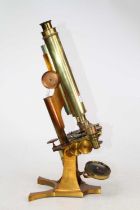 A 19th century brass monocular microscope, the mechanical stage above a Y-shaped foot, inscribed