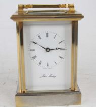 A late 20th century John Morley lacquered brass English carriage clock, having a signed white enamel