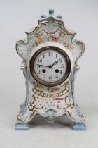 A Victorian Rococo style pottery mantel clock, the enamel dial showing Arabic numerals, having an