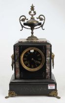 A late 19th century polished black slate and marble mantel clock surmounted with a pedestal urn