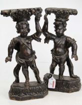 A pair of 19th century carved wood putti, each shown in standing pose carrying a basket of flowers