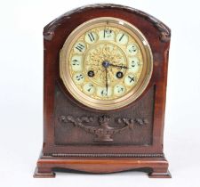 A late 19th century mahogany cased mantel clock of small proportions having a white enamel and