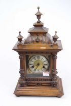 An early 20th century continental walnut cased mantel clock, the silvered chapter ring showing Roman