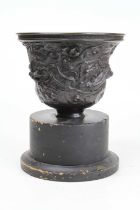 A Chinese bronzed urn, relief decorated with dragons, mounted upon an ebonised plinth, height 25cm