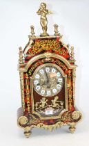 A French style brass and boulle type mantel clock, the dial showing Roman numeral enamel cartouches,