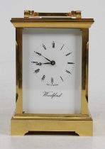 A late 20th century Woodford lacquered brass English carriage clock, having a signed white enamel