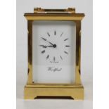 A late 20th century Woodford lacquered brass English carriage clock, having a signed white enamel