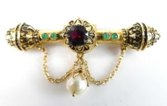 A yellow metal engraved bar brooch in the form of a mace, featuring a round faceted garnet with