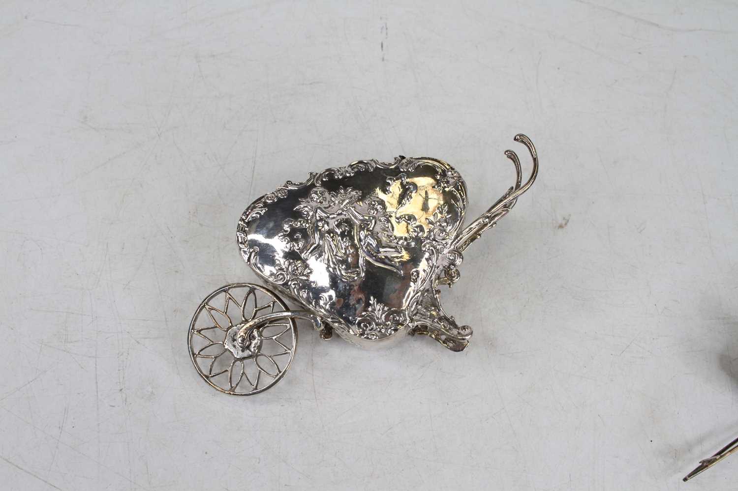 A late 19th century continental silver and embossed miniature wheelbarrow, decorated with winged - Image 2 of 11