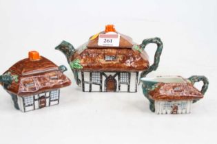 A John Haddock three-piece tea service, each in the form of a cottage, largest height 10cm