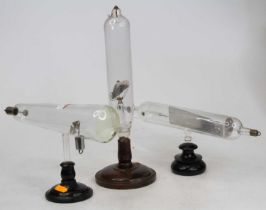 A collection of vintage X-ray equipment, each upon a turned wooden plinth, largest height 34cm