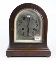 An Edwardian oak cased dome topped mantel clock having an unsigned silvered Arabic dial, the eight-