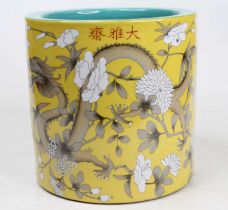 A Chinese yellow glazed porcelain brush pot, enamel decorated with a dragon amongst flowers,