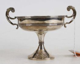 An Edwardian silver pedestal twin handled bonbon dish, the flaring foot with chased coat of arms,