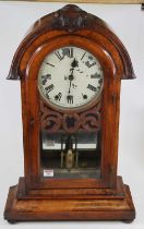 A late Victorian walnut cased dome top mantel clock, having a carved pediment, a painted dial with
