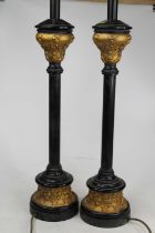 A pair of modern black and gilt table lamps, relief decorated with flowers, height including