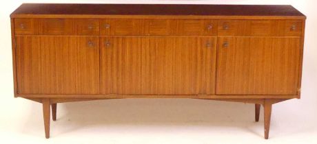 A 1960s British teak sideboard, having three frieze drawers (one with cutlery divisions), over