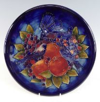 A contemporary Moorcroft pottery charger in the Finches pattern, designed by Sally Tuffin, typically