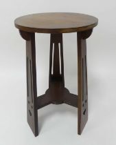 An Arts & Crafts walnut circular occasional table, raised on tapering and pierced supports with