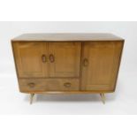 A 1960s Ercol blond elm Windsor 366 compact sideboard, having an arrangement of three cupboard doors