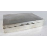 A late Art Deco silver table cigarette box, the hinged engine turned cover enclosing cedar lined