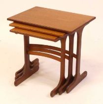 A 1960s G-plan teak nest of three occasional tables, raised on curved outswept supports, united by