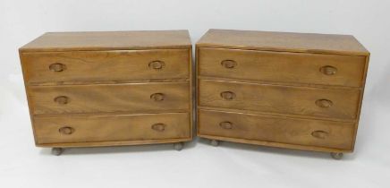 A pair of 1960s Ercol blond elm Windsor 412 low chests of three long drawers, each raised on