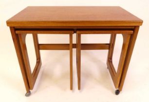 A 1970s teak nest of three occasional tables, by A.H. McIntosh, the largest with swivel fold-over