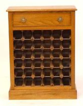 A contemporary oak 36-bottle capacity wine rack with frieze drawer, raised upon a plinth, w.70cm,