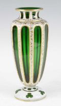 A Bohemian green and white overlaid glass vase, 19th century, decorated with gilt foliage, h.31.