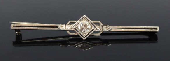 A white metal Art Deco style diamond bar brooch, comprising a centre Old European cut diamond with