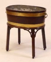 A George III coopered mahogany and brass bound wine cooler of oval form with zinc liner, all