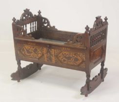 A 19th century continental oak, walnut and marquetry inlaid crib, the panelled sides annotated