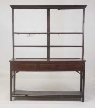 A George III joined oak and elm topped dresser, having a two-tier plate rack over with iron cup