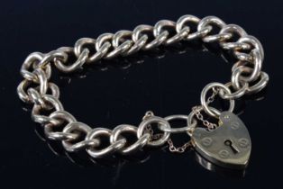 A modern 9ct gold curblink bracelet, with heart shaped padlock clasp and safety chain, each link