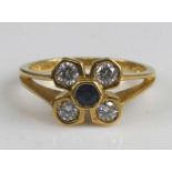 An 18ct yellow gold sapphire and diamond flower head cluster ring, featuring a centre round sapphire