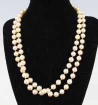 An opera length row of 92 8 to 8.3mm cultured pearls, strung knotted to a white metal sapphire and